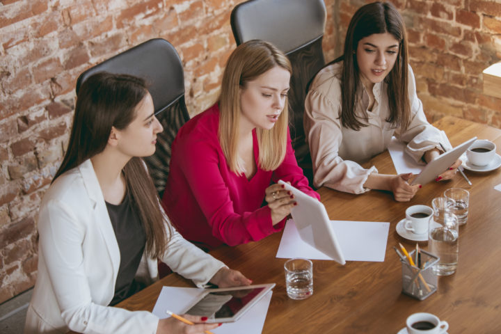 Business young caucasian woman in modern office with team